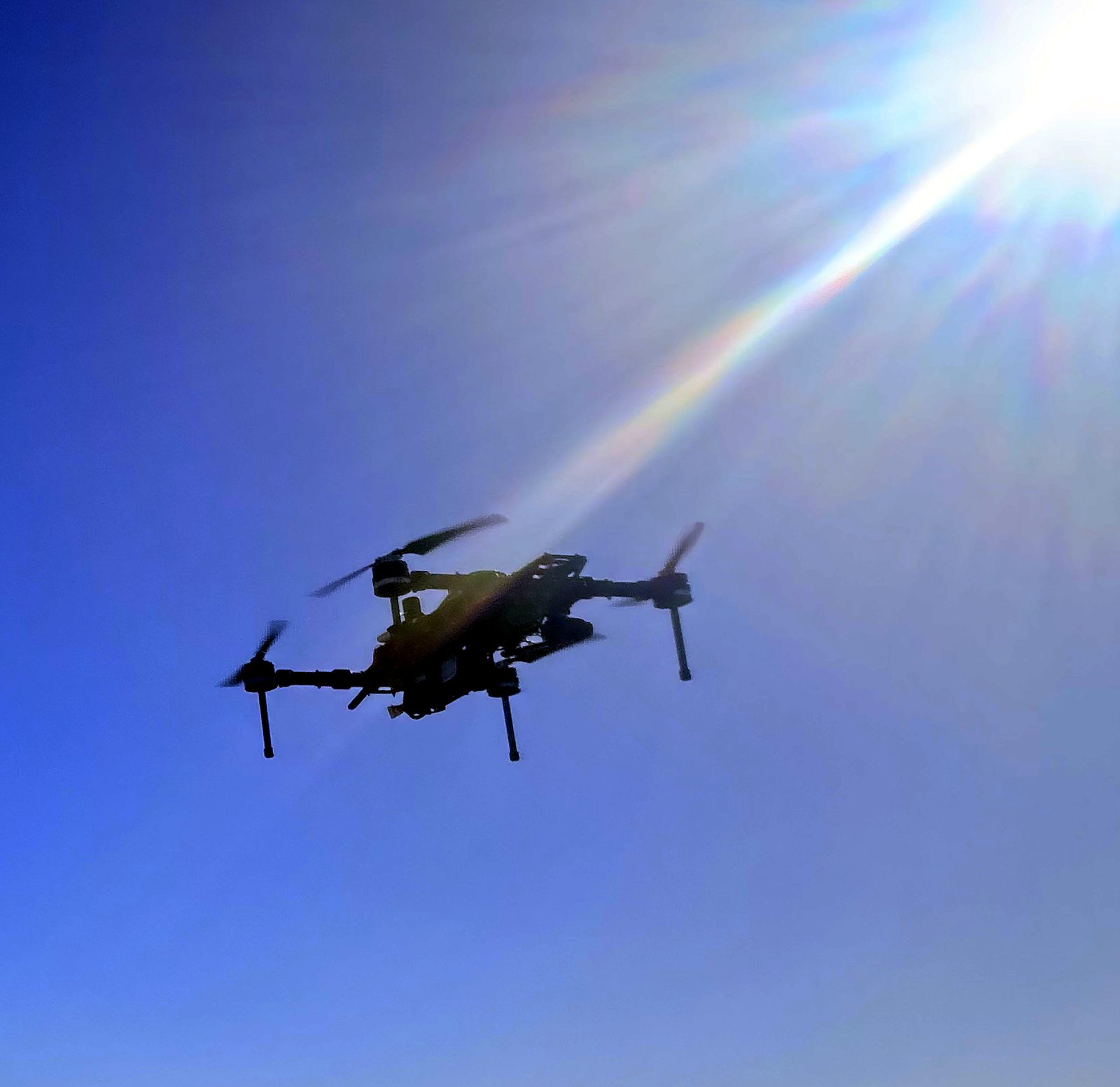 A drone flying over the Transpolis test track under a clear sky